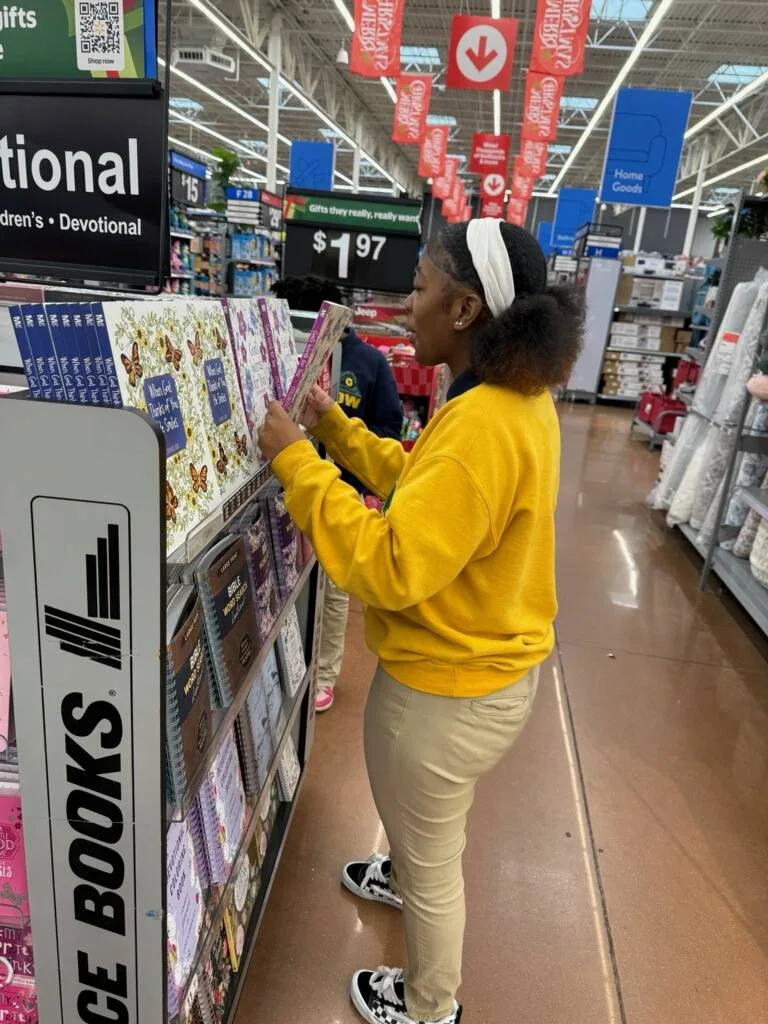 Person browsing books at a store display labeled "Choice Books" in a retail aisle.
