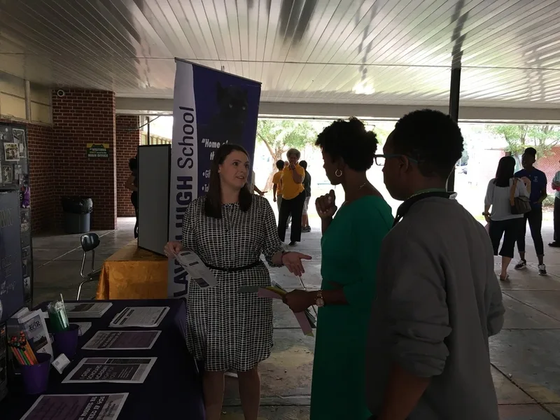 A student and a parent speak with a high school representative.