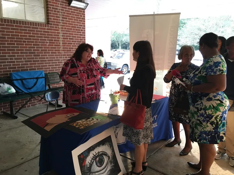 A parent speaks with a representative from a local high school.