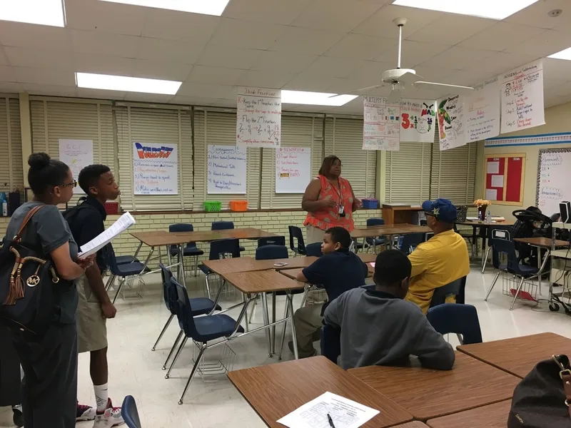 Parents listen to a teacher's open house presentation. 