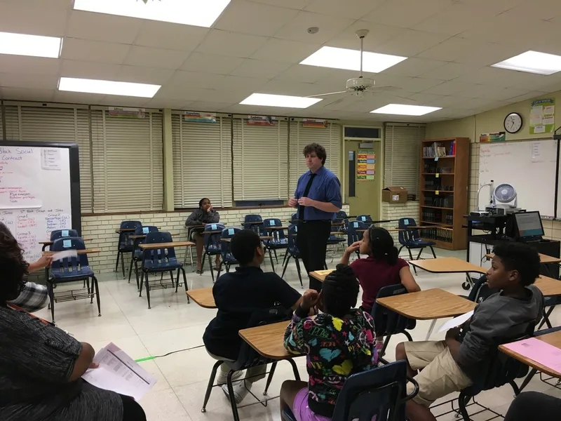 Parents listen to a teacher's open house presentation. 