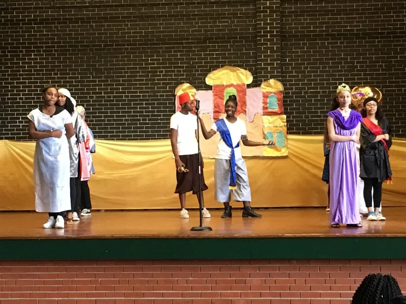 The cast members of the play perform a song and dance. 